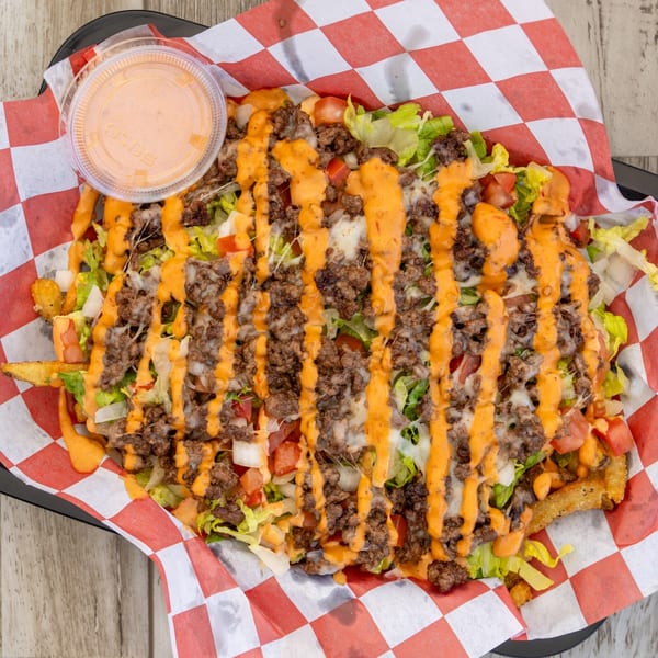 El Chapin's loaded fries with ground beef, cheese, lettuce, tomatoes, and orange sauce.